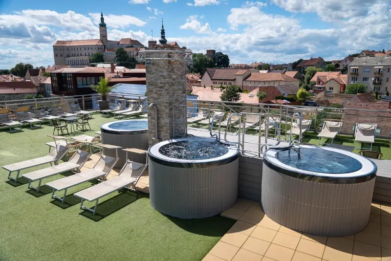 Venkovní vířivky na střešní terase hotelu, v pozadí zámek Mikulov